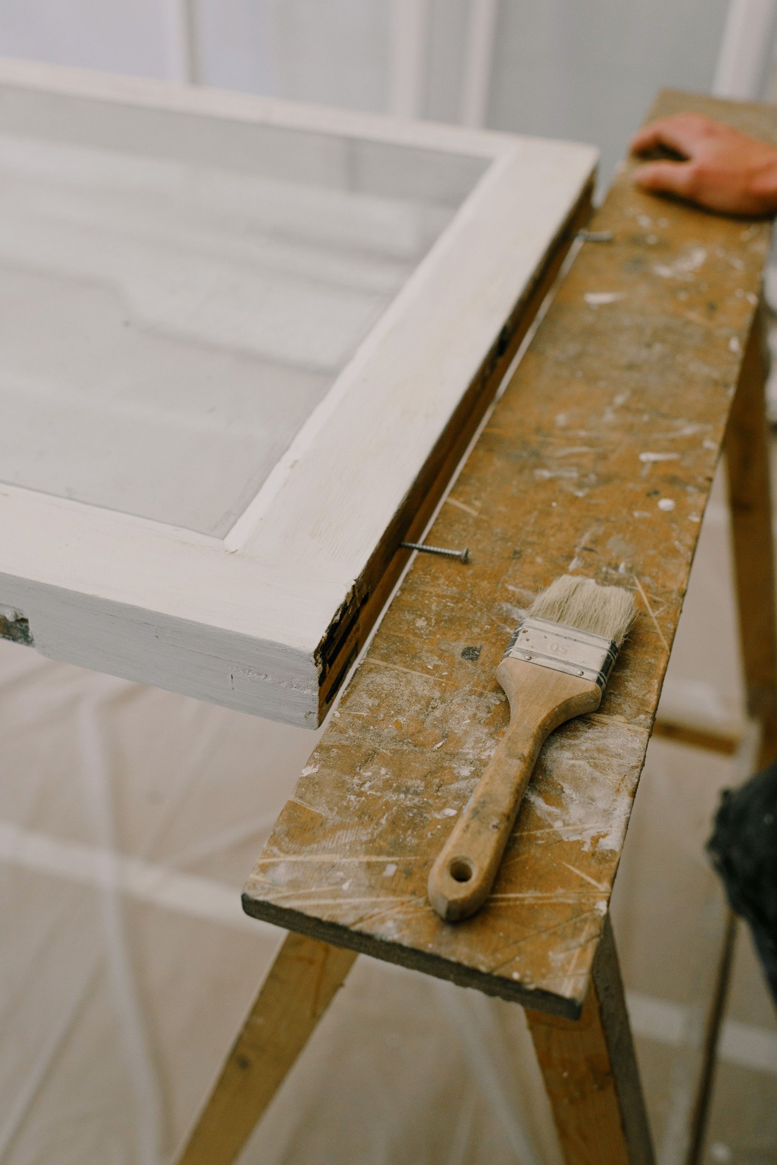 Fensterrahmen aus Holz wird mit dem Pinsel lackiert