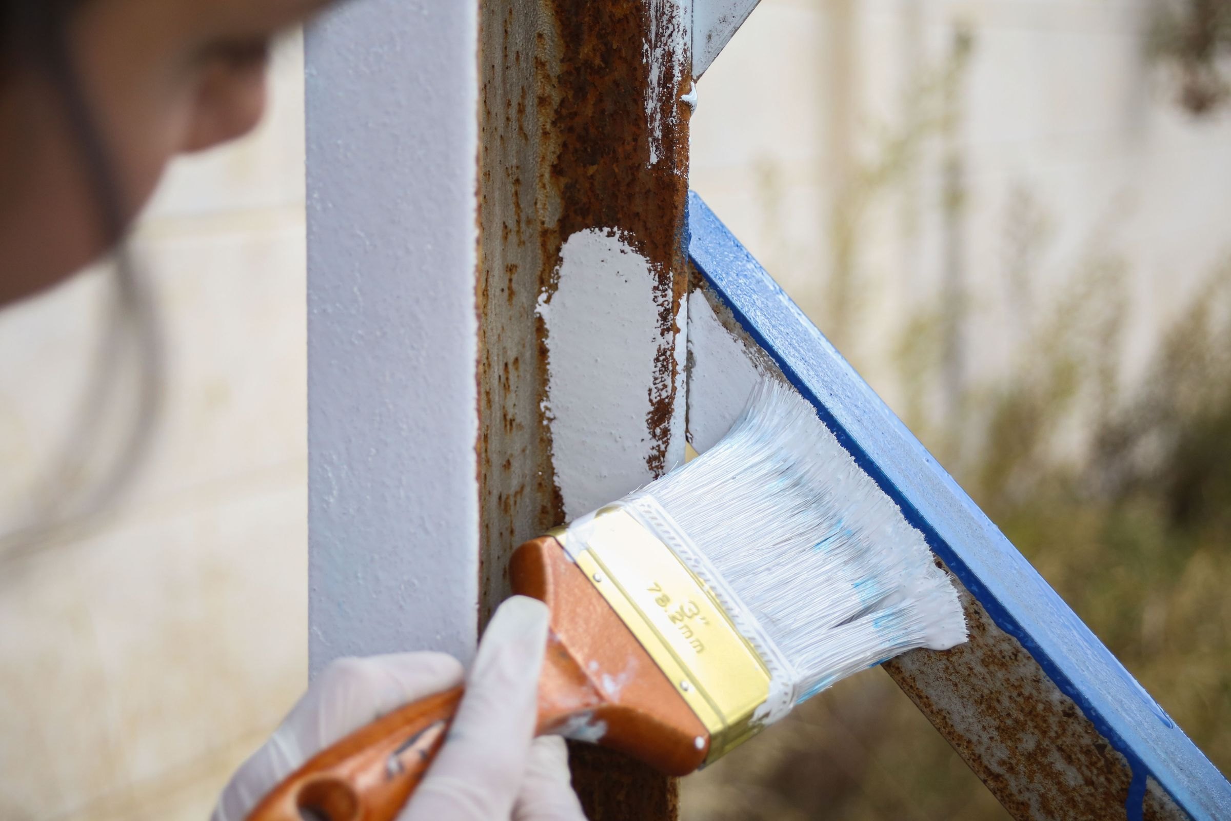 Metallgeländer wird mit dem Pinsel neu gestrichen